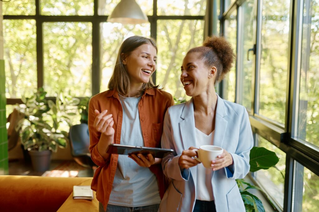 Happy cheerful coworkers chatting at workplace