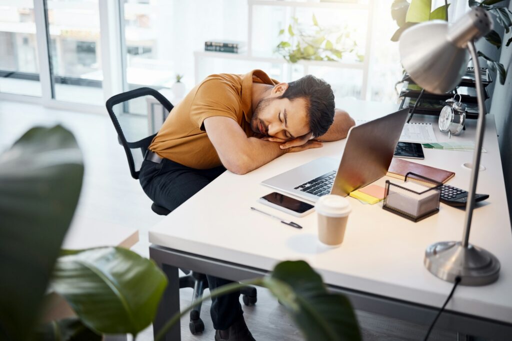 Tired business man sleeping at desk in office with burnout risk, stress problem and relax for low e