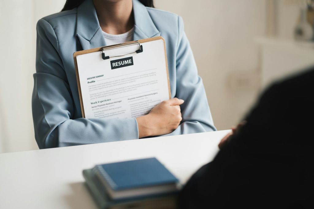 Woman submits job application, Interviewer reading a resume.